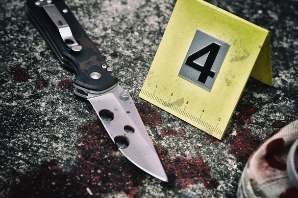 Investigación de la escena del crimen, cuchillo ensangrentado y zapatos de víctima con marcadores criminales en el suelo, pruebas de homicidio
. - Foto, Imagen