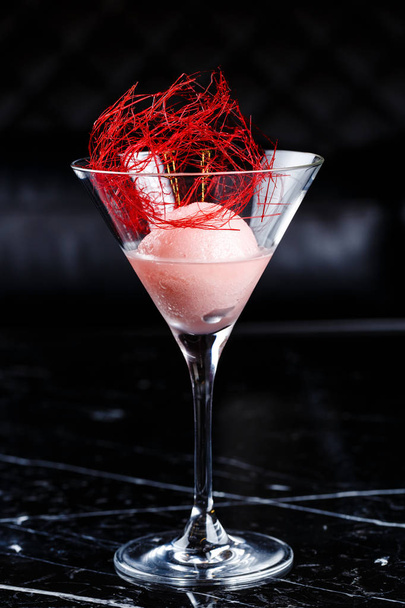 Scoop of the strawberry ice cream in martini glass - Фото, изображение