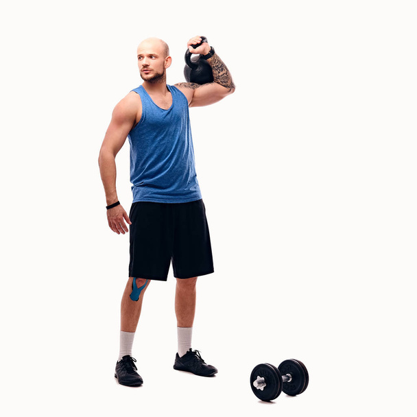 Athletic male doing workouts with kettlebell - Photo, Image