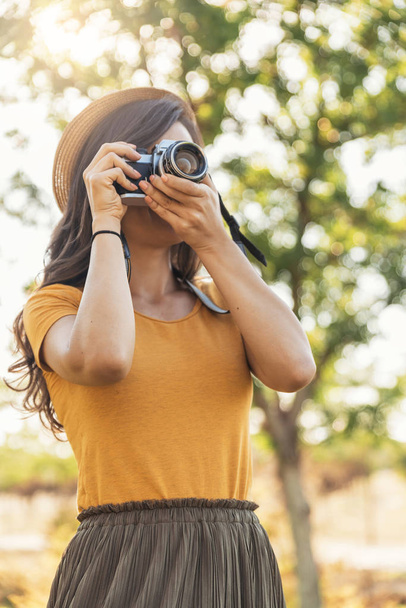 Young woman using a camera to take photo. - Foto, Imagem