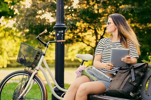 Female using tablet PC in a park. - Foto, Imagen