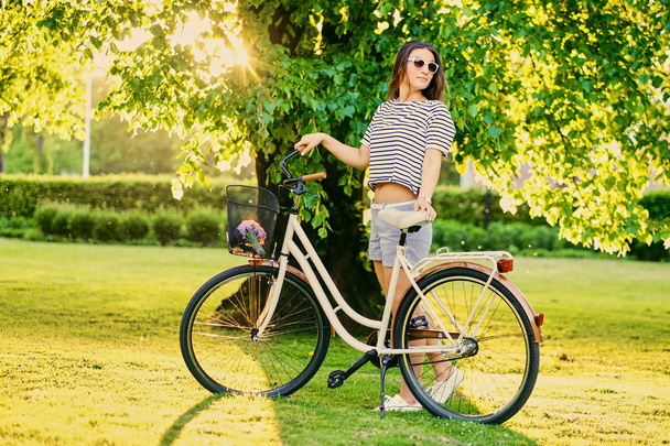 brünette Frau steht mit Fahrrad  - Foto, Bild