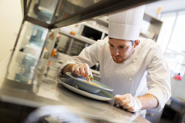 happy male chef cooking food at restaurant kitchen - Foto, Bild
