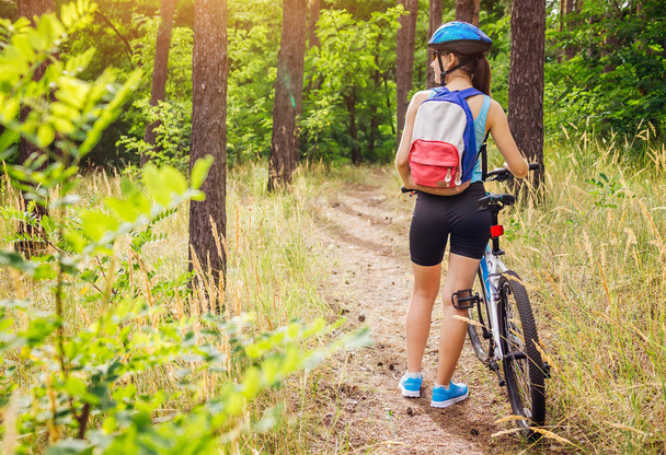 junge Frau mit Fahrrad im Wald - Foto, Bild