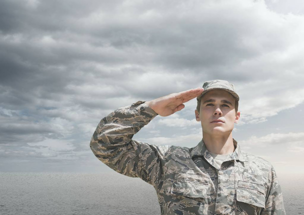 Soldier man raising arm against desert background - Фото, изображение