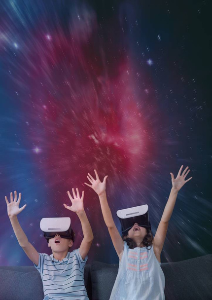 Excited kids in VR headset raising hands against galaxy background - Photo, Image