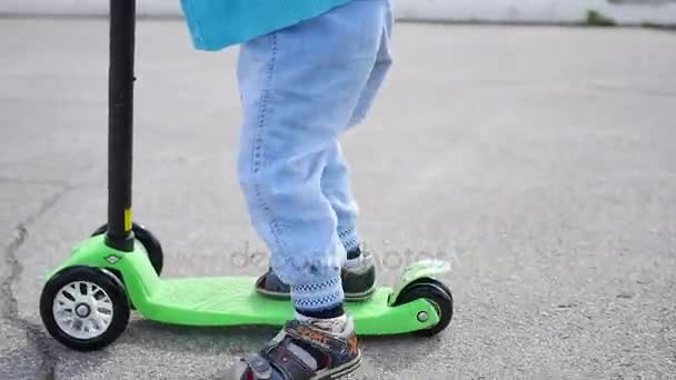 een gelukkig kind rijdt zijn scooter in de buitenlucht Park.Fun - Video