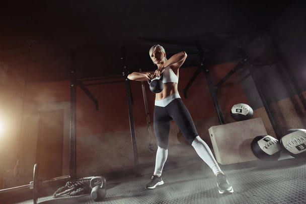 Muscular joven fitness mujer levantando un peso en el gimnasio
 - Foto, Imagen