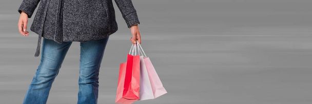 Shopper bas du corps avec sacs sur fond gris flou
 - Photo, image