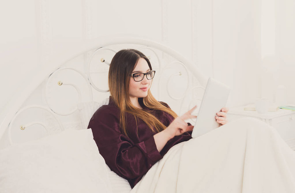 Жінка читає з планшетного ПК в ліжку, копіювати простір
 - Фото, зображення