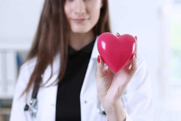 Vrouwelijke geneeskunde arts handen met rood hart - Foto, afbeelding