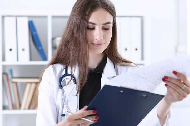 Medizinerin hält Klemmbrett in der Hand - Foto, Bild