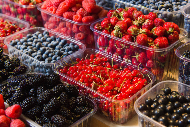 Trays of fresh berries on display at local market. - Фото, изображение