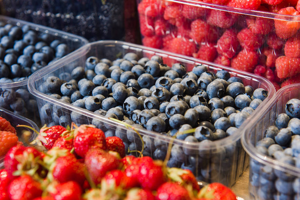 Trays of fresh berries on display at local market. - Foto, imagen