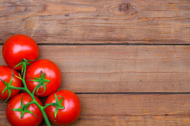 Red juicy tomatoes on a wooden table top view, free space. - Foto, Imagem