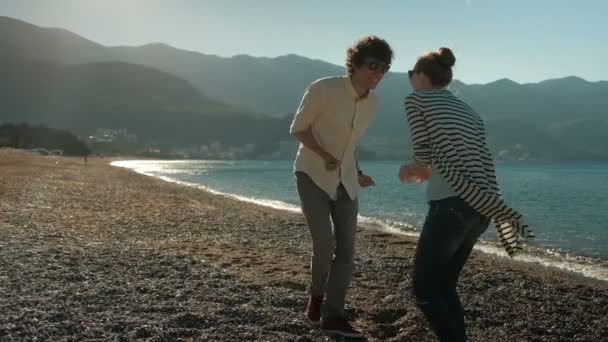 Paar plezier dansen in de zonsondergang op het strand. - Video