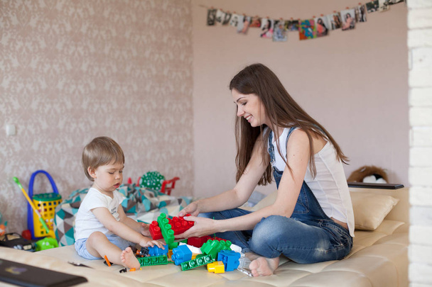 mother and little boy play with toys in the nursery - Fotoğraf, Görsel