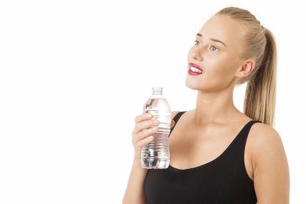 Jeune femme souriante tenant une bouteille d'eau
  - Photo, image