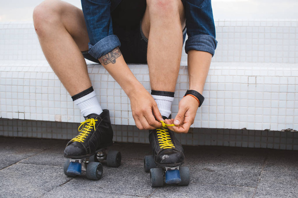 Young caucasian man with quad skates rolls with wound on leg - Photo, Image