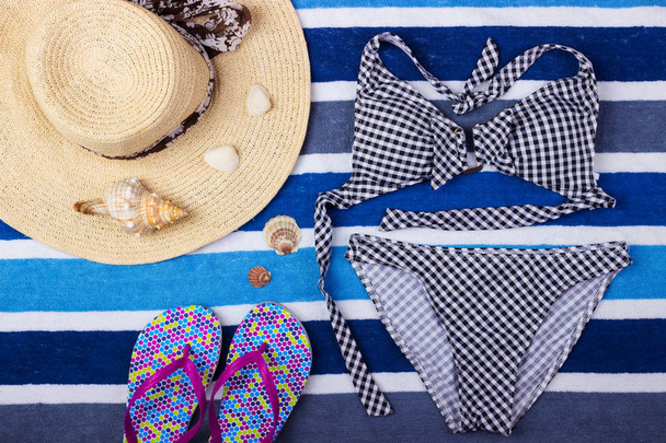 Summer background with straw hat, flip flops and swimsuit. Top view - Photo, Image