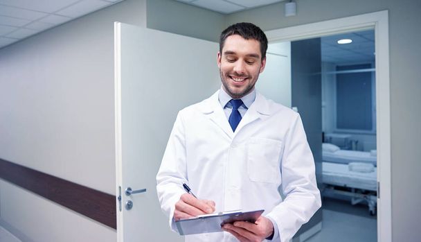 smiling doctor with clipboard at hospital - Fotoğraf, Görsel