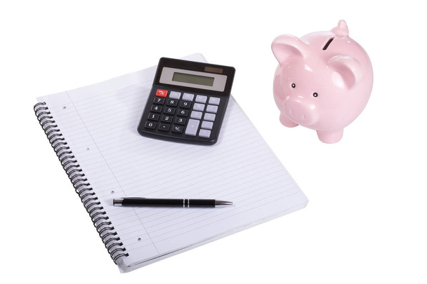 Piggy bank met een rekenmachine, een Kladblok en een pen - Foto, afbeelding