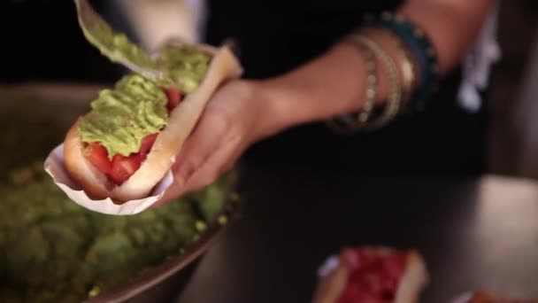 Vrouwelijke handen voorbereiden hotdog - Video