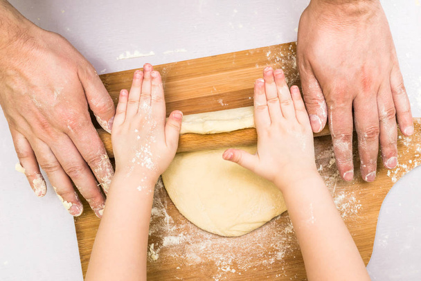Children and dad hands rolled dough - Photo, Image