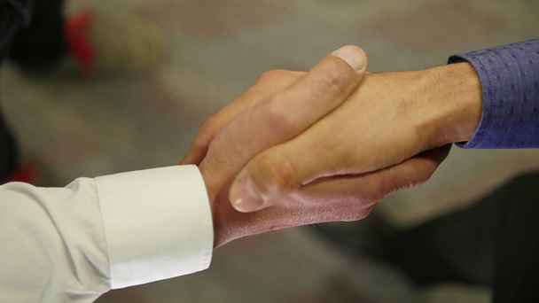 dos personas estrechando las manos
 - Metraje, vídeo