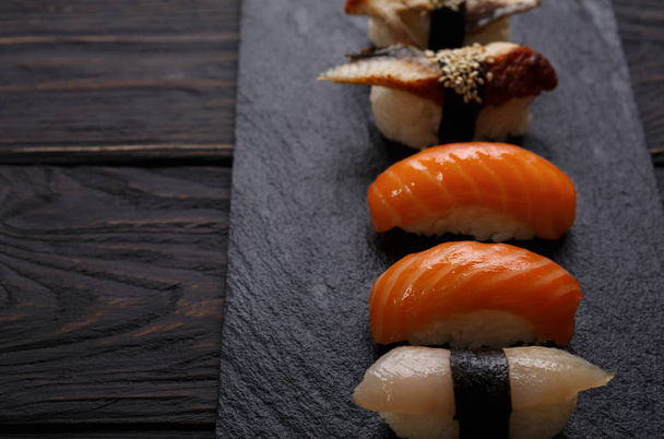 Set of sushi on black wood background, pov - Фото, изображение