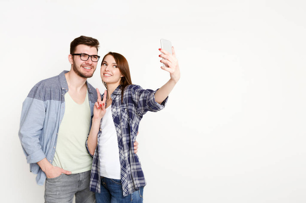 Happy casual couple doing selfie on smartphone, isolated - Фото, зображення