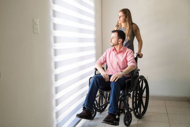 Smutný muž na invalidním vozíku se svým partnerem - Fotografie, Obrázek