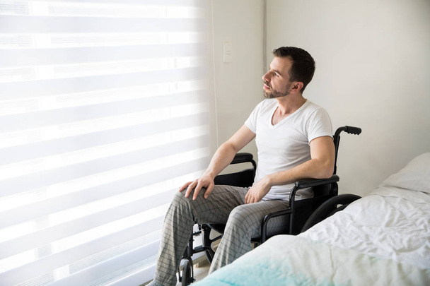 Přemýšlivý muž na invalidním vozíku doma - Fotografie, Obrázek