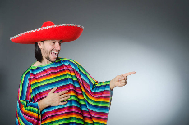Man in een levendige Mexicaanse poncho grijze achtergrond geïsoleerd - Foto, afbeelding