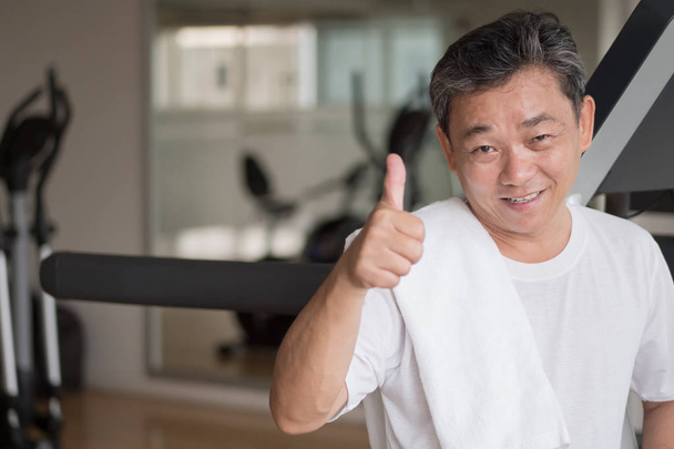 zdravý, šťastný starší muž cvičit v tělocvičně, dává palec nahoru ge - Fotografie, Obrázek