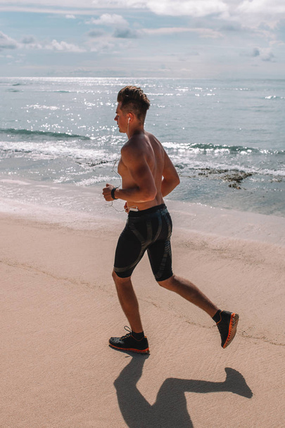 Jovem atleta muscular treina na praia do oceano Índico, Indonésia, Bali
 - Foto, Imagem
