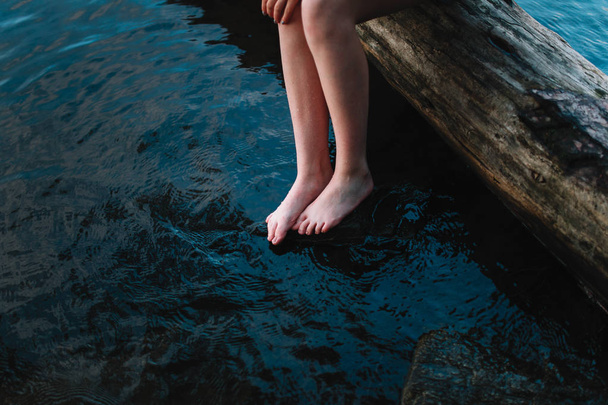 woman touching water of lake with toes - Foto, imagen