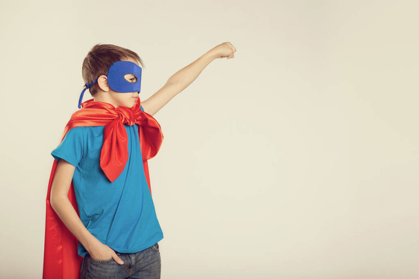 Little superhero boy in costume raised his hand up. copyspace, toned. - Photo, Image