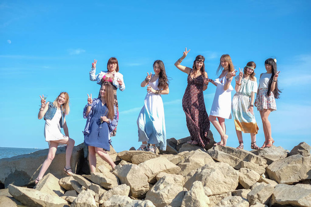 Grupo de mujeres jóvenes de pie juntas en una playa en un día de verano. Jóvenes felices disfrutando de un día en la playa
. - Foto, Imagen