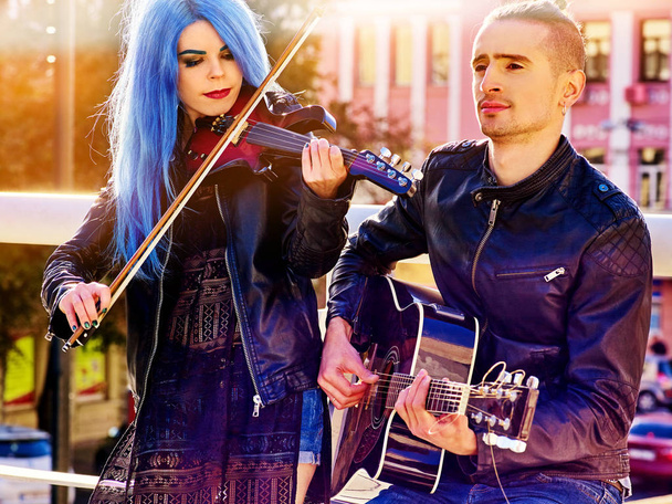 Woman and man perform music on violin city outdoor. - Photo, Image