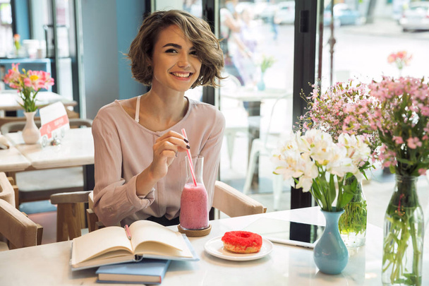 Smiling pretty girl drinking smoothie with a straw - Zdjęcie, obraz