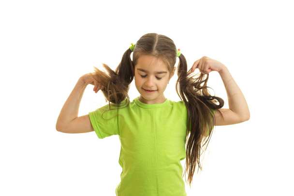 lustiges kleines Mädchen mit Zöpfen im grünen Hemd - Foto, Bild