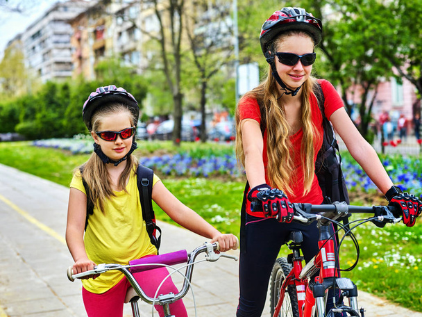 Μονοπάτι ποδήλατο με τα παιδιά. Τα κορίτσια φορούν κράνος με σακίδιο . - Φωτογραφία, εικόνα