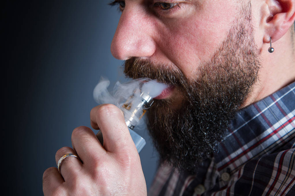 beared man  smoking electronic cigarette - Foto, afbeelding