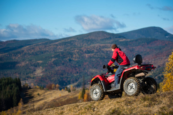 Male on an ATV riding down the hilly road  - Photo, Image
