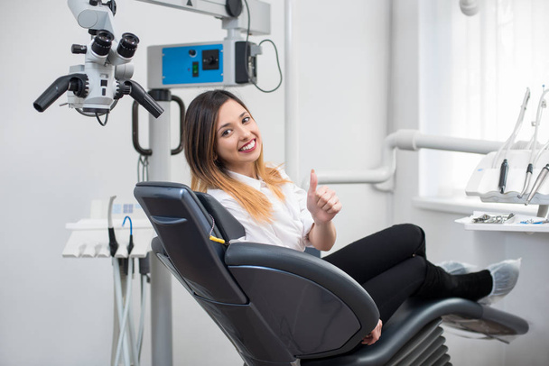 patient dans une chaise dentaire montrant les pouces vers le haut
  - Photo, image