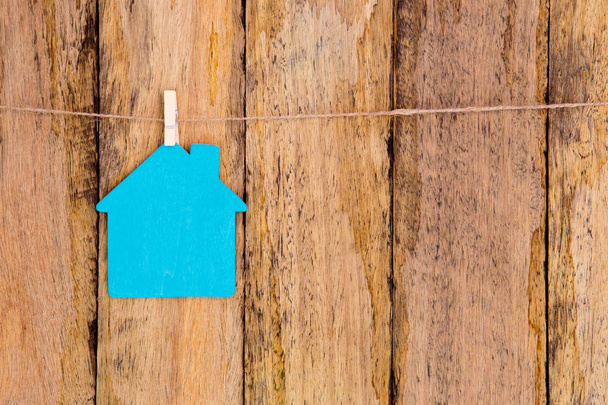 Blue color wooden house shape hanging on string against rustic w - Photo, Image