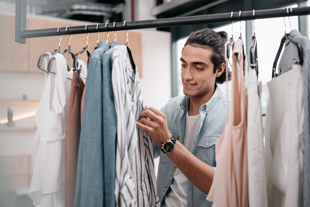 hombre trabajando con ropa en boutique
 - Foto, imagen