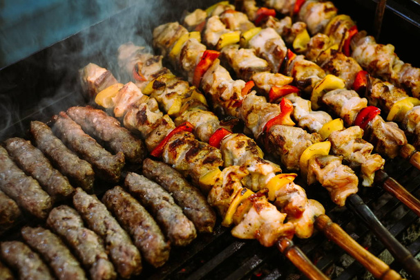 Grilling chicken meat skewers and kebab with vegetables on barbecue charcoal grill - Photo, Image