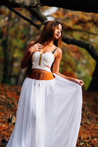Fantastic young woman. beautiful fantasy girl fairy with white long dress in windy autumn park - Fotografie, Obrázek